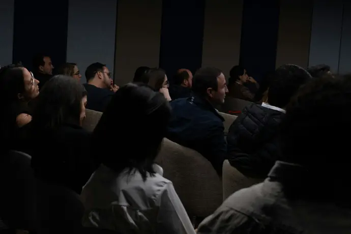 a group of people sitting in a dark room